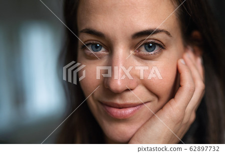 Attractive businesswoman standing indoors in office, looking at camera. 62897732