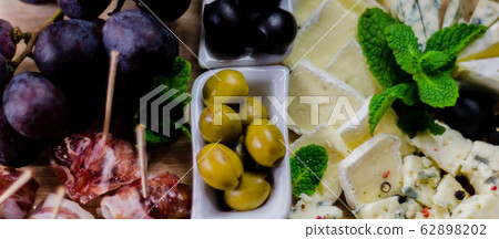 Green olives served with a variety of cheeses and Green olives served with a variety of cheeses and 62898202