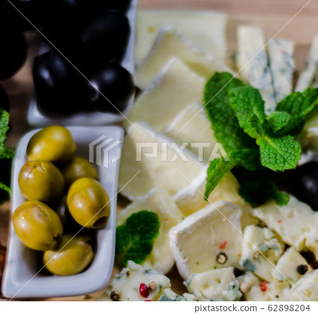 Green olives served with a variety of cheeses and Green olives served with a variety of cheeses and 62898204