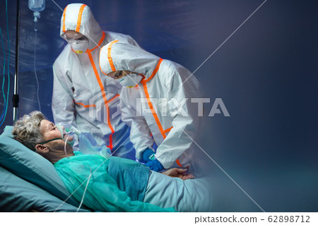 Infected patient in quarantine lying in bed in hospital, coronavirus concept. Infected patient in quarantine lying in bed in hospital, coronavirus concept. 62898712
