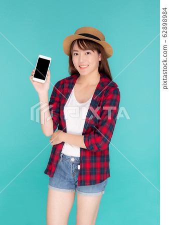 Beautiful young asian woman showing smart mobile phone for presenting something in travel 62898984