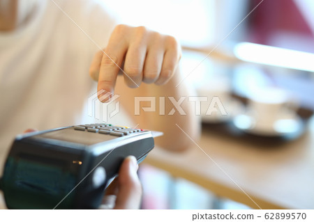 Man dials a PIN code at terminal, payment by card Man dials a PIN code at terminal, payment by card 62899570