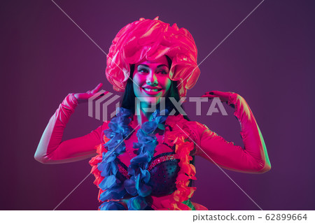 Attractive hawaiian brunette model on purple studio background in neon light 62899664
