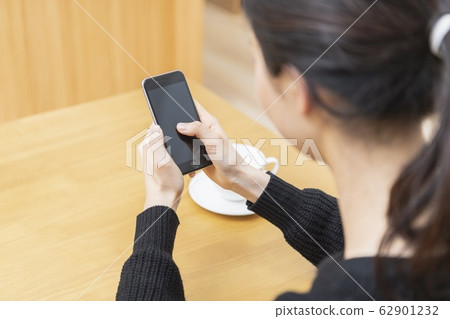 Hand of a woman who operates a smartphone 62901232