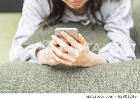 一位睡覺並操作智能手機的女士 62901249