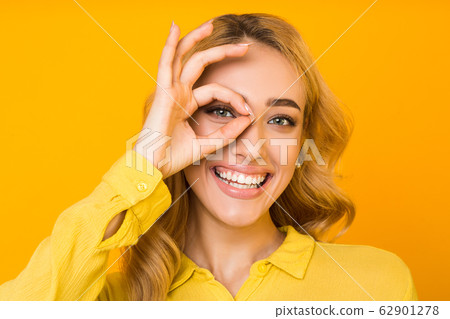All is ok. Girl gesturing okay sign with hand on eye 62901278