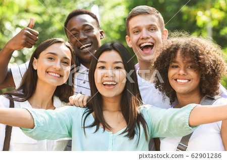 Group of multi-ethnic teen friends taking selfie picture outdoors 62901286