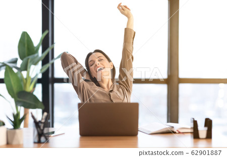 Happy european manager stretching body at work Happy european manager stretching body at work 62901887