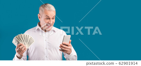 Happy mature man holding mobile phone and money dollars Happy mature man holding mobile phone and money dollars 62901914