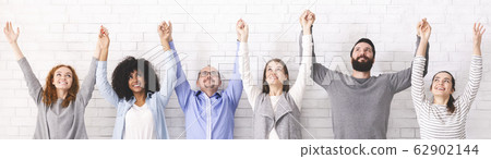 Group of happy diverce people holding hands, raising arms up, panorama Group of happy diverce people holding hands, raising arms up, panorama 62902144