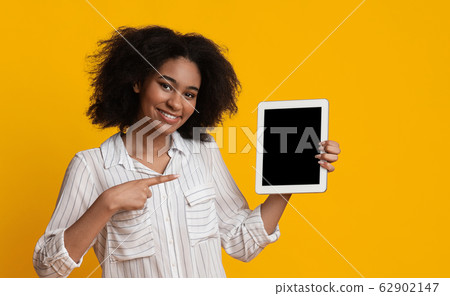 Smiling Woman Holding And Pointing At Digital Tablet With Black Screen Smiling Woman Holding And Pointing At Digital Tablet With Black Screen 62902147