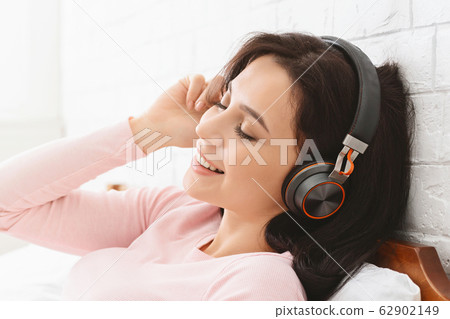 Happy woman enjoying great sound of new headset 62902149