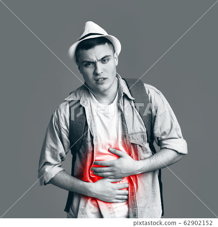 Tourist suffering from stomachache, holding highlighted with red belly Tourist suffering from stomachache, holding highlighted with red belly 62902152