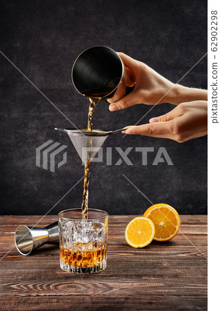 Hand of bartender with shaker and strainer  62902298