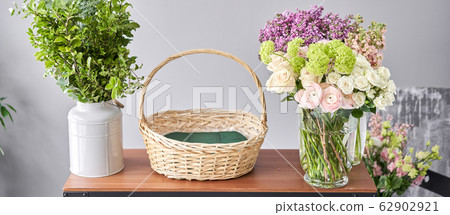 Education in the school of floristry. Master class on making bouquets. Summer bouquet in a wicker basket.. Learning flower arranging, making beautiful bouquets with your own hands. Flowers delivery 62902921