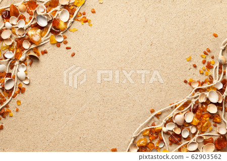 Ambers And Seashells On Sea Sand Background 62903562