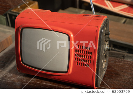 Retro old red TV set reciever on wooden table Retro old red TV set reciever on wooden table 62903709