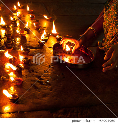 People burning oil lamps as religious ritual in 62904960