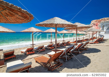 Sandy beach with chairs for relaxation. Milos 62905002