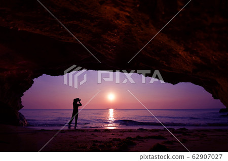Silhouette of woman standing using camera to take Silhouette of woman standing using camera to take 62907027