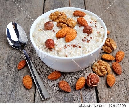 Oatmeal porridge with dried , nuts and raisin isolated on white backgrounds. Oatmeal porridge with dried , nuts and raisin isolated on white backgrounds. 62910309