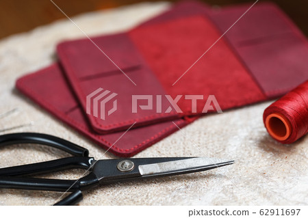 A leather craftsman works with leather. Sews A leather craftsman works with leather. Sews 62911697