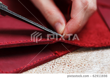 A leather craftsman works with leather. Sews A leather craftsman works with leather. Sews 62911698