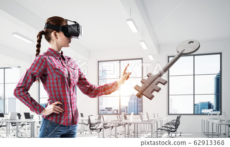 Girl in virtual reality mask experiencing virtual technology wor 62913368
