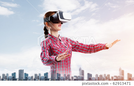 Girl in checked shirt wearing VR glasses experiencing another reality Girl in checked shirt wearing VR glasses experiencing another reality 62913471
