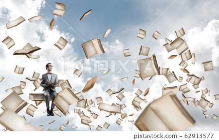 Young businessman or student studying the science and books fly around Young businessman or student studying the science and books fly around 62913577