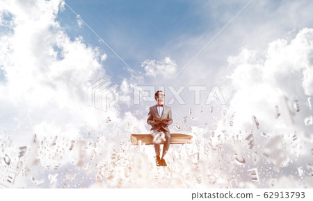 Young businessman or student studying the science and symbols fly around Young businessman or student studying the science and symbols fly around 62913793
