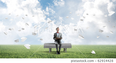 Young businessman or student studying the science and paper planes fly around 62914428