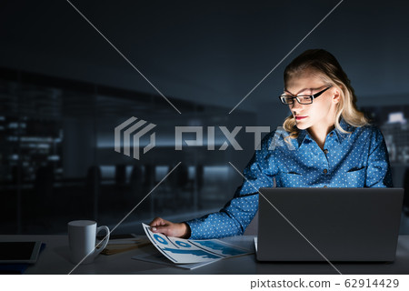 Beautiful blonde in dark office working on laptop and getting net access Beautiful blonde in dark office working on laptop and getting net access 62914429