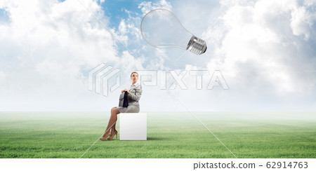Attractive business lady or accountant outdoors on white box Attractive business lady or accountant outdoors on white box 62914763