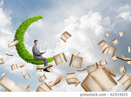 Man reading book and many of them flying in air Man reading book and many of them flying in air 62914835