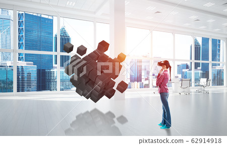 Girl in virtual reality mask experiencing virtual technology world. Mixed media Girl in virtual reality mask experiencing virtual technology world. Mixed media 62914918
