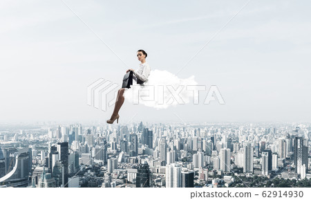 Businesswoman or accountant on cloud floating high above modern Businesswoman or accountant on cloud floating high above modern 62914930