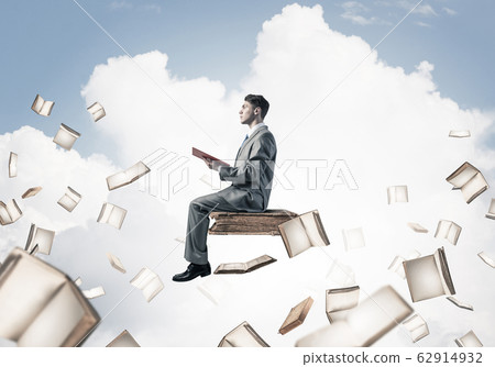 Man reading book and many of them flying in air Man reading book and many of them flying in air 62914932