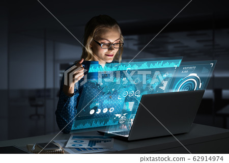 Beautiful blonde working on laptop and infographs out of screen. Mixed media Beautiful blonde working on laptop and infographs out of screen. Mixed media 62914974