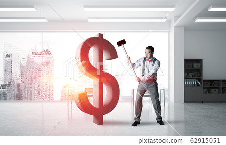 Determined banker man in modern office interior breaking dollar figure Determined banker man in modern office interior breaking dollar figure 62915051