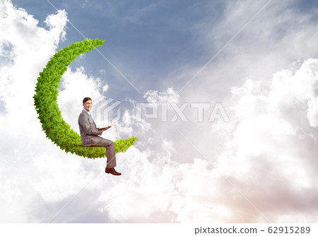 Businessman or student sitting on green moon and reading book Businessman or student sitting on green moon and reading book 62915289