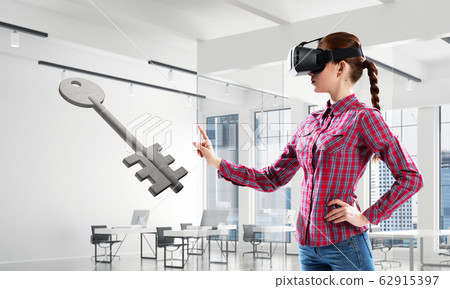 Girl in virtual reality mask experiencing virtual technology world. Mixed media 62915397