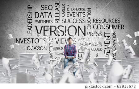Attractive man sitting on pile of paper documents. 62915678