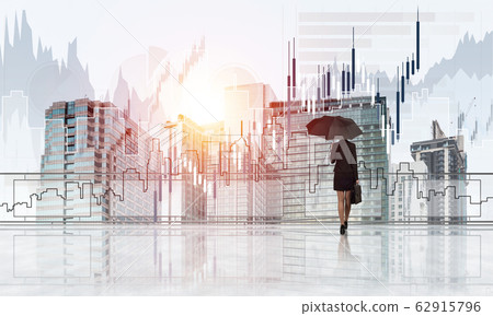 Elegant businesswoman standing with back and looking at modern business cityscape. Mixed media Elegant businesswoman standing with back and looking at modern business cityscape. Mixed media 62915796