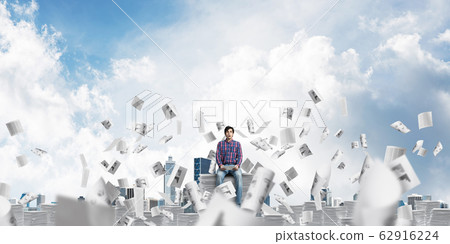Attractive man sitting on pile of paper documents. Attractive man sitting on pile of paper documents. 62916224