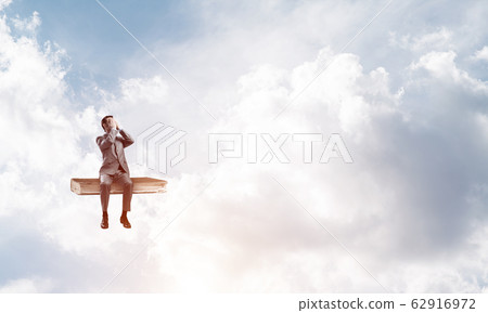 Young man on book in blue sky do not want to see anything 62916972