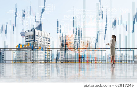 Sunrise above skyscrapers and businesswoman facing new day 62917249