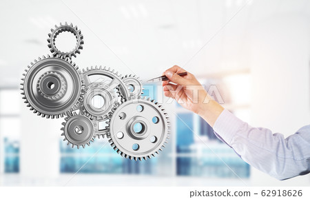 Engine mechanism in male hands as symbol for cooperation or team Engine mechanism in male hands as symbol for cooperation or team 62918626