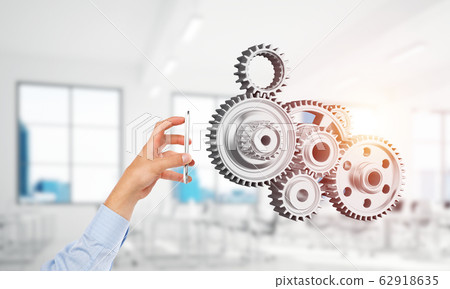 Engine mechanism in male hands as symbol for cooperation or teamworking. Mixed media 62918635