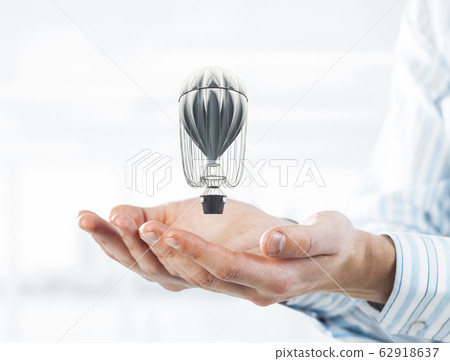 Concept of travel and imagination with aerostat in male palms. M 62918637